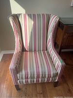 Front view of the striped upholstered wing back chair with visible fabric pattern and cushion seat.