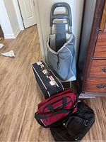 Photo showing all four items: travel cart, two carry-on bags, vintage suitcase