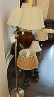 Full view of the metal floor lamp with fabric shade among other lamps, showing the swing arm and shade shape
