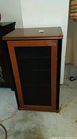 Full view of the wooden stereo cabinet showing front metal door insert and wood frame.