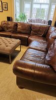 Three-piece sectional arranged around ottoman in living area