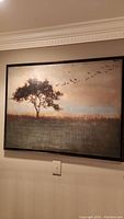 Full view of framed canvas landscape wall art showing a tree and flying birds in muted earth tones.