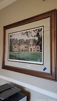 Framed and matted print showing a large stately home with grass foreground and trees in the background, signed and numbered by Tom Caldwell.