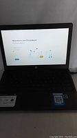 Front view of HP Chromebook powered on showing the welcome screen to the Chromebook setup process.