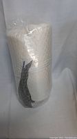 Memory foam bolster pillow in clear plastic wrapping, quilted cover visible
