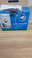 The blue product box labeled Ozone Generator with a photo of the device on front and included instruction manual on top.