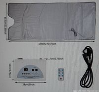 Photo showing gray sauna bag with head opening, control unit, remote control, and power cord laid flat with dimension markings.