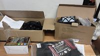 Photo of boxes on wooden surface including bug zapper, solar LED potting lights, and parts visible