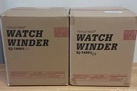 Two sealed cardboard boxes labeled 'Triple Tree Watch Winder GJ-14001US' on a wooden surface