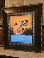 Framed original acrylic painting showing stylized wolves with sunset, trees, and water