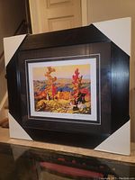 Full view of professionally framed and matted art print "Autumn In Northland" by Franklin Carmichael, outside frame with corner protectors.