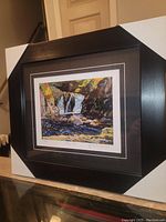 Photo of framed and matted fine art print in black frame with double matting displaying "Little Falls" waterfall scene.