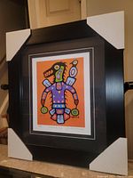 Framed and matted colorful Thunderbird art print with protective corner pads on frame