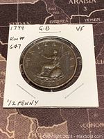 Reverse side of the 1799 Great Britain half penny coin showing seated Britannia holding shield and trident.