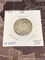 Front side of the coin showing maple leaf wreath and 25 cents label with year 1919 marked on holder.