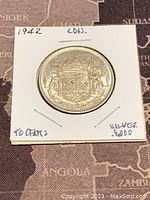 Front of 1942 Canadian 50 cents silver coin showing the Canadian coat of arms with crown and supporters, denomination marked as 50 cents and the year 1942.