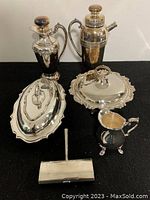Full lot view showing 6 silver plated pieces including cocktail shaker, pitchers, covered dish, tray, and sweeper tray.
