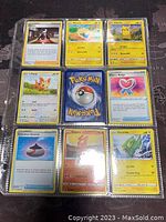 Photo showing a page of 9 Pokémon cards including Lillipup, Marang, Pikachu, Electrike, Slugma, and Trainer cards.