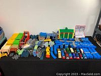 Overview of the full lot laid out on a table showing all trains, tracks, bridges, buildings, and accessories.