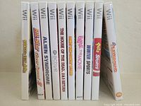 Photo showing 10 Wii game cases lined up side by side, titles visible on spines.