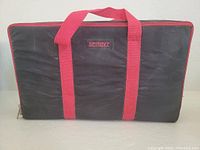Black Sprint brand carrying case with red carrying handles and trim, closed, showing exterior