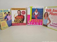 Front view of all four fitness books showing full covers and titles.