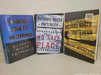 Front view of the three Richard North Patterson novels show cover art of Eyes of a Child, No Safe Place, and Silent Witness.