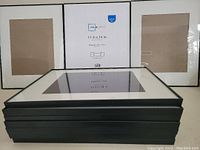 Ten black picture frames stacked horizontally, each with white mats sized for 8x10 photos inside 11x14 frame size