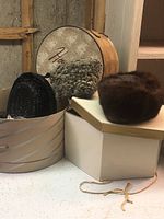 Various angles of four handmade hats and two fascinator head coverings, showing textures and styles including fur, fabric, and sequins.