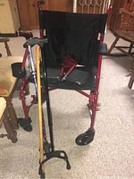 Front view of Medline collapsible wheelchair with three canes resting in front