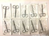 Top view of ten individually sealed new sterile Littauer surgical scissors arranged in two rows of five on a white surface.