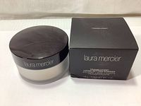 Photo of the Laura Mercier Loose Setting Powder jar with black lid and original packaging box. Powder is translucent, 29g net weight.