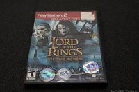 Front cover of The Lord of the Rings The Two Towers video game for PlayStation 2 showing title, characters and logos.