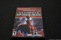 Front cover of the Ultimate Spider-Man PlayStation 2 game case showing the title, artwork, and logos.