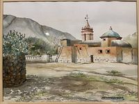 Close-up of the watercolor painting showing a Mexican adobe building with a dome and bell tower, surrounded by desert landscape, signed by artist.