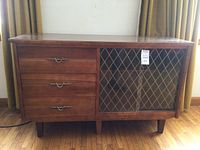 Full front view of walnut sideboard showing three drawers at left and leaded glass doors at right