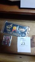 Two collectable pins shown on a surface with a lot number card. One pin is sealed on a black card with Star Trek Lives logo; the other is a Wolverine metal pin in a clear plastic case.