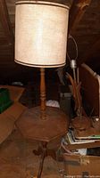 Full view of the wooden table lamp showing the octagonal table base and turned wood central column along with the fabric drum lampshade on top.