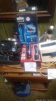 Braun Series 33040s shaver in box, hot lather machine, alarm clock, and other items on wooden dresser