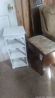 Photo showing both the floral upholstered padded wooden stool and the white wooden shelf with three shelves.
