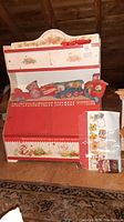 Wooden toybox showing upper bookcase area with drawers and bottom with alphabet and strawberry decorations. Condition shows wear, bottom separated from base.