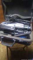 General Electric CH-9806 VHS camcorder inside a hard-shell carrying case, showing the camcorder and accessories with cables inside the case.