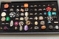 Tray of approximately fifty assorted rings showing various styles and colors
