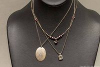 Front view of all three 925 silver necklaces displayed on black stand, showing pendants and bead details.