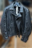 Front view of men's black leather biker jacket with visible zippered pockets and asymmetric front zipper.