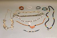 Full view of all necklaces and bracelets laid out on a surface showing colors, styles, and general condition.
