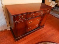 Front view of the wooden buffet showing one drawer, two cabinet doors, brass handles, and overall condition