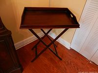 Overall view of the dark wood tall butler's tray table with removable tray on stand.