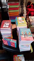 Stack of books including Diary of a Wimpy Kid, Baby-Sitters Club, and other children's books piled on a chair.