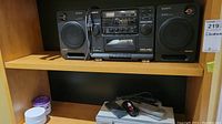 Sony CFD-440 boombox with two speakers on wooden shelf